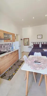 a kitchen and dining room with a table and a bed at Il Principe casa vacanze in Trabia