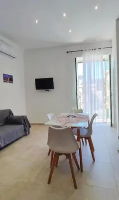a white living room with a table and chairs at Il Principe casa vacanze in Trabia