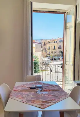 a table with a wine glass on top of a window at Il Principe casa vacanze in Trabia