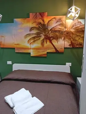 a room with a bed with four palm trees paintings at ABT L'AURA in Palermo
