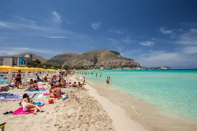 a group of people on a beach in the water at casa di Enrico in Palermo