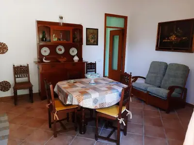 a dining room with a table and chairs and a couch at casa di Enrico in Palermo