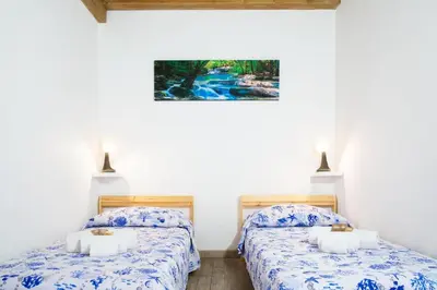 two beds in a room with white walls at Meg Sicily House in Castellammare del Golfo