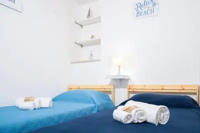 two beds in a room with towels on them at Meg Sicily House in Castellammare del Golfo