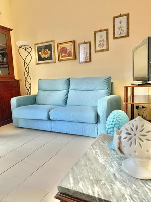 a blue couch in a living room with a table at Daziarosetta in Palermo