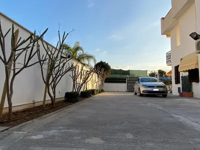 a car parked in a parking lot next to a building at VILLA DELLE POMELIE in Isola delle Femmine