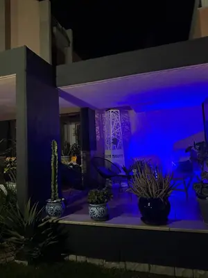 a house with a blue light on a patio with plants at Flat with Jacuzzi - Casa Pia in Mondello