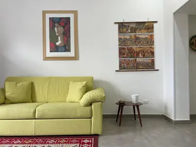 a living room with a yellow couch and a table at Case Orlando_a city center Sicilian treat in Palermo
