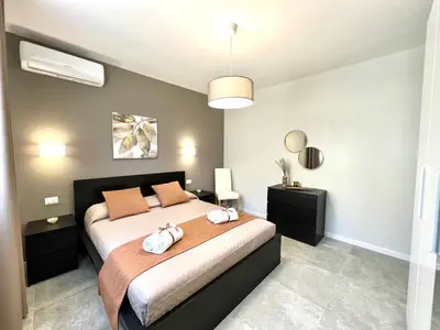 a bedroom with a bed with two towels on it at Piante del Principe Apartments in Carini