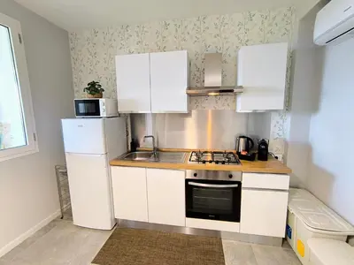 a small kitchen with white cabinets and a refrigerator at Piante del Principe Apartments in Carini