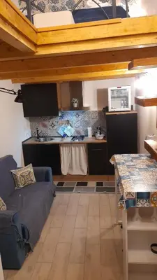 a living room with a couch and a kitchen at Casa vacanza Gio in Palermo