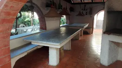 two benches sitting in a room with a table at Villa Mare Ercole Luxury in Trappeto