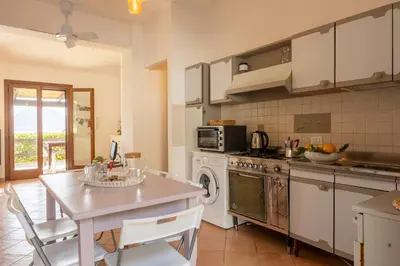 a kitchen with a table and a stove and microwave at Pittalumari Makari in Macari