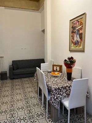 a dining room with a table and chairs and a couch at SPYDA in Palermo