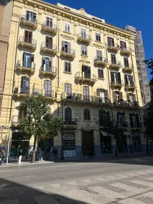 a large yellow building with balconies on a street at SPYDA in Palermo