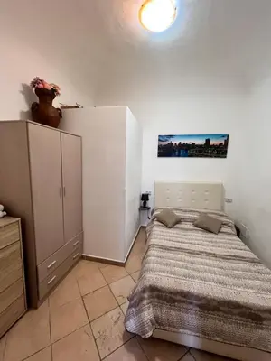 a bedroom with a bed and a cabinet in it at House del Corso Calatafimi in Palermo