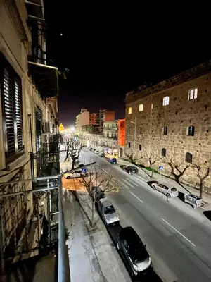 a city street at night with cars parked at House del Corso Calatafimi in Palermo