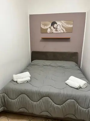 a bed with two towels and a picture on the wall at House del Corso Calatafimi in Palermo