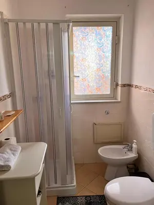 a bathroom with a shower and a toilet and a window at House del Corso Calatafimi in Palermo