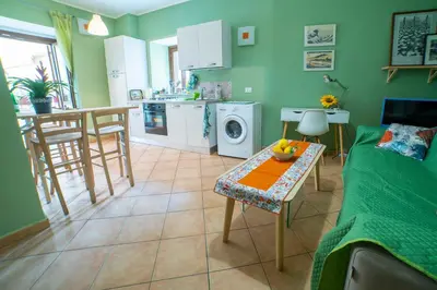 a kitchen and living room with a couch and a table at Happie Casa Il Capo & La Cattedrale in Palermo