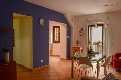 a living room with a table and a blue wall at Happie Casa Il Capo & La Cattedrale in Palermo
