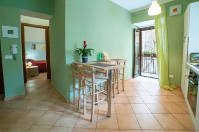 a kitchen with green walls and a table with stools at Happie Casa Il Capo & La Cattedrale in Palermo