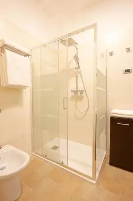 a bathroom with a shower and a toilet and a sink at M'Place - Mondello Residence in Palermo