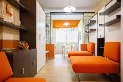 a living room with orange chairs and a table at M'Place - Mondello Residence in Palermo