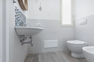 a white bathroom with a sink and a toilet at GuestHost - La Casa di Martina - Palermo Central Apartments in Palermo