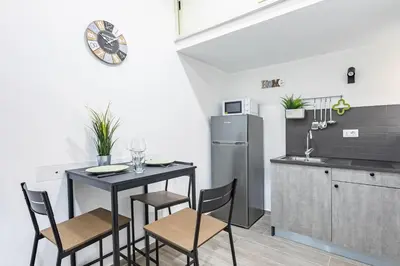 a kitchen with a table and chairs and a refrigerator at GuestHost - La Casa di Martina - Palermo Central Apartments in Palermo