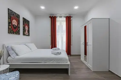 a bedroom with a white bed and red curtains at GuestHost - La Casa di Martina - Palermo Central Apartments in Palermo