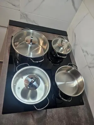 four pots and pans on a stove in a kitchen at MeliKris home in Palermo