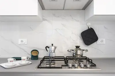 a kitchen counter with a stove with a tea kettle and cups at Federica's House - Sporting Village in Scopello
