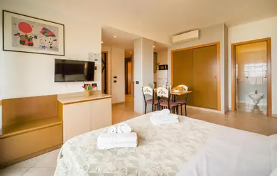 a bedroom with a bed and a kitchen and a table at Bilo 4 in Lido di Mondello