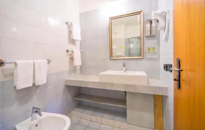 a white bathroom with a sink and a mirror at Bilo 4 in Lido di Mondello