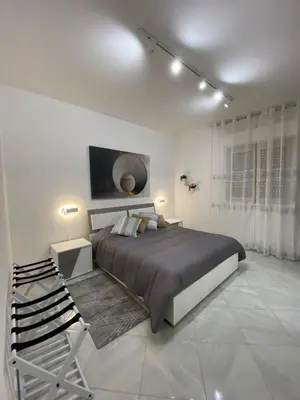 a bedroom with a large bed in a white room at Perla Diva Apartment in Palermo