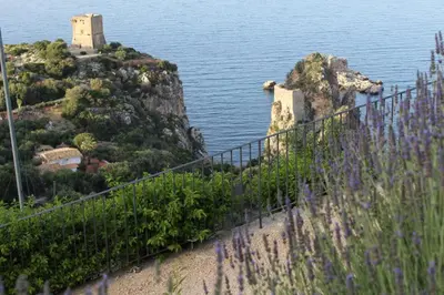 a view of an island in the water with purple flowers at CasAnna in Castellammare del Golfo