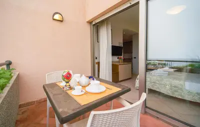 a table with a tea set on it in a balcony at Bilo 4 in Lido di Mondello