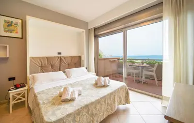 a bedroom with a bed and a view of the ocean at Bilo 4 in Lido di Mondello