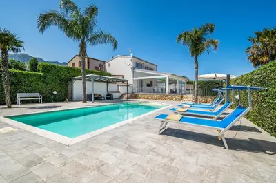 a swimming pool with palm trees and a house at Villa Dell'Ulivo con piscina privata By Sicily Home Solutions in Alcamo