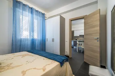 a bedroom with a bed and a window with blue curtains at Villa Dell'Ulivo con piscina privata By Sicily Home Solutions in Alcamo