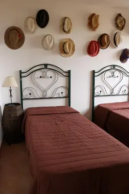 a bedroom with two beds and hats on the wall at Belle Vue Sarmuci in Scopello
