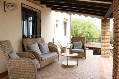 a patio with wicker chairs and a table on a patio at Belle Vue Sarmuci in Scopello