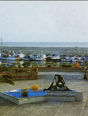 a statue in front of a marina with boats at Casa Alice in Isola delle Femmine