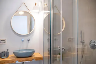 a bathroom with a glass shower with a sink and a mirror at Le Tartane B&b Guidaloca in Castellammare del Golfo