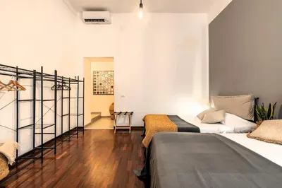 a room with two beds and a chair in it at Don Mimì Leisure in Palermo