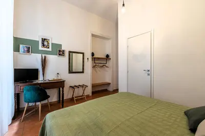 a bedroom with a bed and a desk and a television at Don Mimì Leisure in Palermo