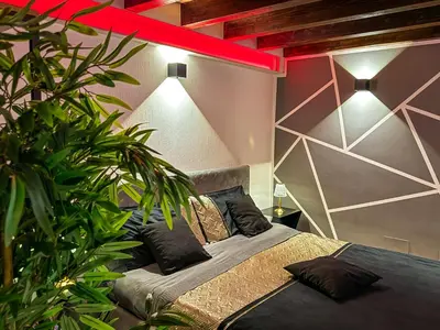 a bedroom with a bed and a large plant at Rouge Suite & SPA PALERMO CENTRO in Palermo