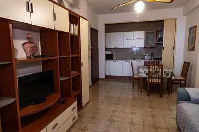 a living room with a television and a dining room at L'isola Che Non C'è in Isola delle Femmine