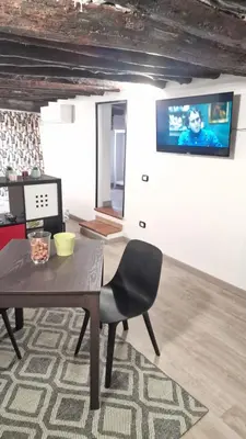 a dining room with a table and a tv on the wall at Virginia House 3 in Palermo